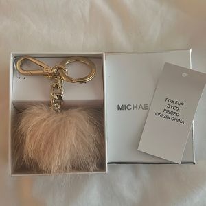 Micheal Kors Fox Fur Pom Pom key chain in a dusty pink color.